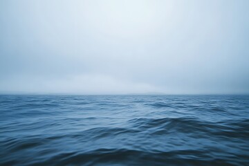 Moody ocean scene with deep blue tones, overcast sky, and smooth, flowing water movement.