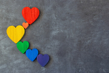 Fototapeta premium Rainbow hearts on the black background. The sing of Lgbt flag.