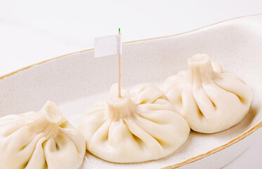 Dumplings served on a simple plate with a small flag for identification