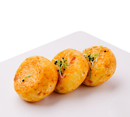 Deliciously golden baked potato dumplings served on a white plate