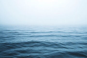 Fototapeta premium Vast open ocean with smooth waves, misty atmosphere, horizon line fading into white