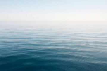 Obraz premium Serene Ocean Horizon: A tranquil view of the ocean with calm waters and a gradient sky, creating a sense of peace and vastness.