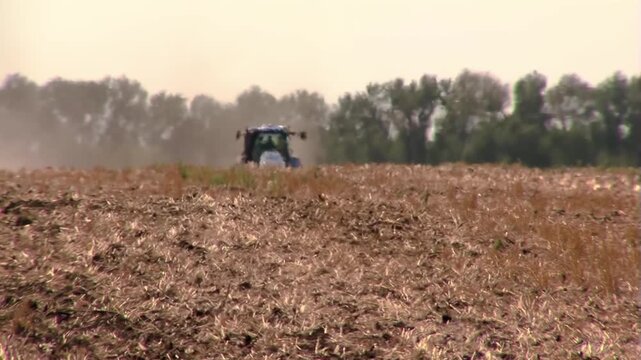 Real footage of an intense heat mirage: Shimmering air and atmospheric distortion create a natural wavy visual effect, with a tractor in the background.