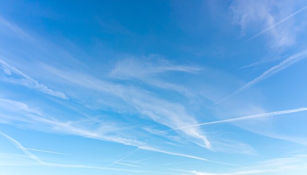 Clear blue sky with wispy clouds and jet trails