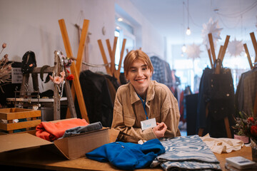 A young retail worker diligently engaged in a stylish store with trendy clothing