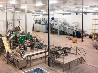 Inside a modern food processing plant with advanced industrial machinery and workers.