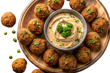 Falafel balls arranged on a wooden plate with a bowl of hummus dip topping