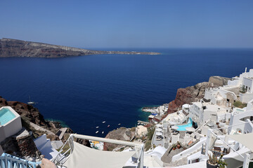 Whitewashed houses with terraces and pools and a beautiful view in Oia on Santorini island, Greece