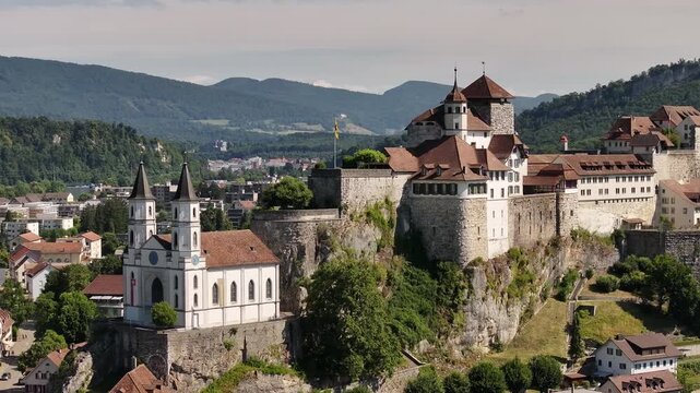 aerial of historic aarburg castle and white church perched above the aare river switzerland
