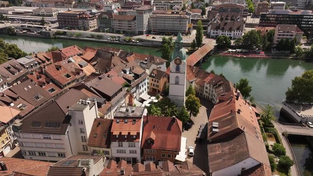 aerial - red tiled roofs circle clocktower and wooden bridge in olten solothurn switzerland