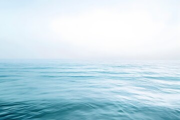 Fototapeta premium Light ocean breeze creates moving surface lines, white sky above, spacious open design area.