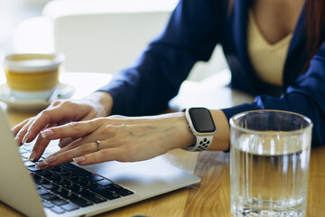 Young business woman sitting in a cafe and working on her laptop