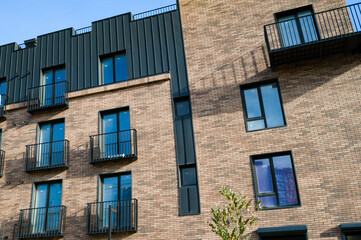 Modern architectural design showcases a blend of brick and metal elements in a stylish urban setting during a sunny afternoon