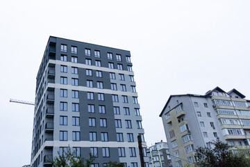 Fototapeta premium Modern apartment buildings rise against a gray sky in a contemporary urban setting