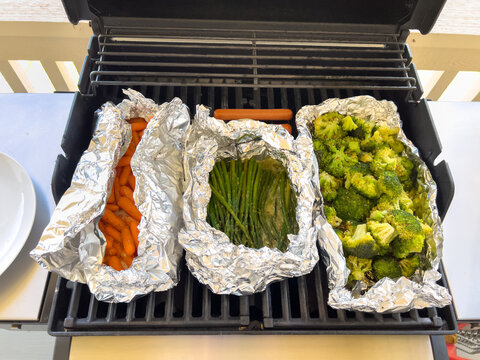 Three Foil Vegetable Packs on Outdoor Grill