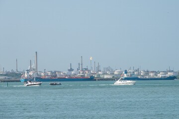 Warsash England - August 11 2024:  motor boats in the Solent passing by Fawley Refinery Hampshire