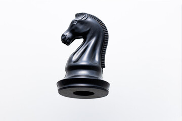 Black chess knight on white background, strategy concept © Mariia