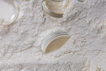 Texture of white fine flour, macro shot with round flat cabochons inside, studio shot