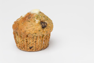 Fresh Zucchini Muffin with Chocolate Chips and a Pad of Melting Butter on a White Background