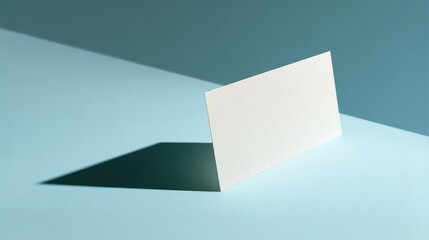 Blank business card mockup, studio shot, blue background, sunlight shadow, design template