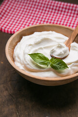 Plain greek yogurt in wooden bowl  on wooden board