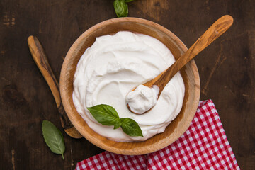 Plain greek yogurt in wooden bowl  on wooden board
