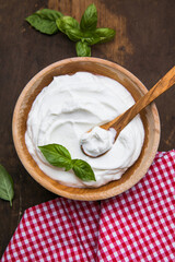 Plain greek yogurt in wooden bowl  on wooden board