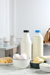 Different dairy products and eggs on white marble table indoors