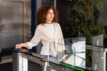 Businesswoman opening office turnstile using electronic key card
