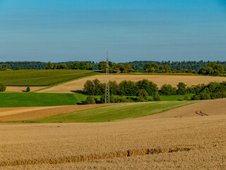 Obraz premium Hochspannungsmasten im Feld