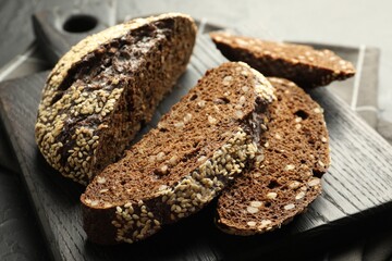 Pieces of fresh rye bread with seeds on table, closeup