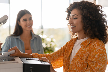 Office workers using printer in modern office