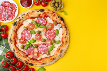 Delicious pizza and ingredients on yellow table, flat lay. Space for text
