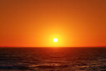 Fiery sunset over a vast ocean.  A bright, round sun sits atop a fiery orange sky, mirroring the color onto the flat horizon of the ocean below.  Ocean waves gently ripple