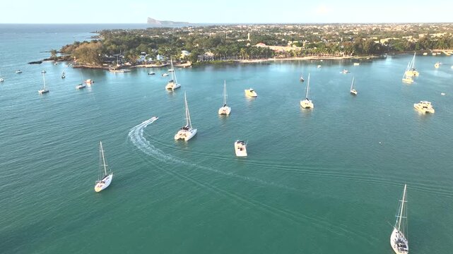 Aerial view of tranquil coastline with sailing boats and yachts in clear blue ocean, Grand Baie, Riviere du Rempart, Mauritius.