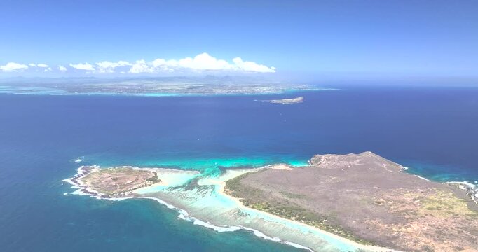 Aerial view of a beautiful flat island surrounded by turquoise ocean and serene coastline, Riviere du Rempart, Mauritius.