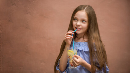 Cute little girl drinks lemonade.