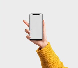 A hand holding a smartphone with a blank screen against a light gray background. The hand is wearing a mustard yellow sweater