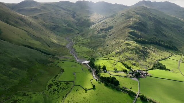 Farm At Foot Of Mountain In Steep Sided Rugged Valley With Pools Of Summer Sunshine And Winding Stream. Great Langdale, Lake District, Cumbria, UK.