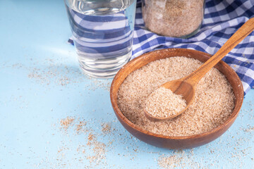 Whole Psyllium Husk in spoon, bowl and jar, with glass of water, natural alternative to pills or injections for weight loss. Additional fiber source, adsorbent, dietary supplement for healthy eating