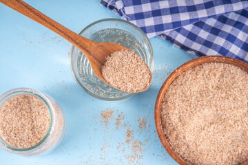 Whole Psyllium Husk in spoon, bowl and jar, with glass of water, natural alternative to pills or injections for weight loss. Additional fiber source, adsorbent, dietary supplement for healthy eating