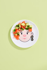 Vegetable salad with tomatoes and cucumbers, bright lighting, overhead composition on a playful childs plate