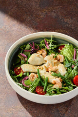 Squid and shrimp green salad with pine nuts, bright natural lighting, overhead composition