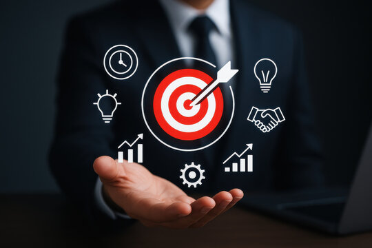 Businessman holding target with arrow and business icons, symbolizing success and strategy