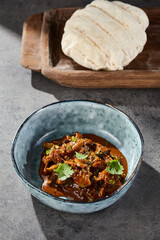 Eggplant spread with fresh cilantro, bright studio lighting, overhead composition, pita bread on rustic wood