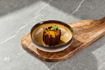 Passion fruit and chocolate pastry in bright lighting, overhead composition on rustic wood board