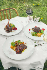 Meat dish set with rich sauce, outdoor rustic lighting, overhead composition, summer fine dining restaurant menu