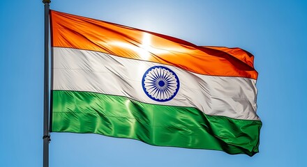 The national flag of India waving proudly in the wind against a bright blue sky, symbolizing freedom and patriotism.