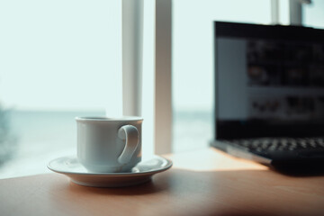 Cup of coffee and laptop on vintage iron table.