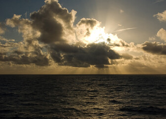Sunlight breaking through clouds over the ocean